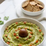 1a Guacamole-Dip serviert mit Low-Carb Cracker — servierfertiger ketogener Party-Snack