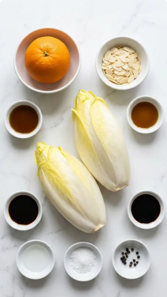 Zutaten für Chicoreesalat mit Orangen: frischer Chicorée, eine saftige Orange, Mandelblättchen und feines Walnussöl