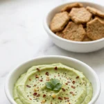 feine Avocado Creme kohlenhydratarm — samtiger grüner Avocado-Dip in kleiner Schale