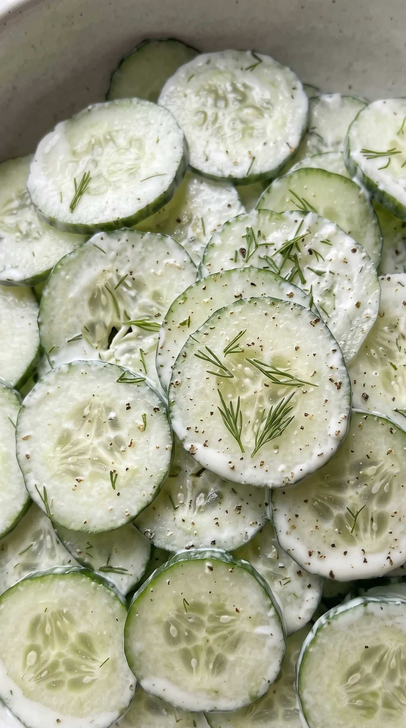 Nahaufnahme von Keto Gurkensalat — hauchdünne Gurkenscheiben in Sauerrahm-Dill-Dressing